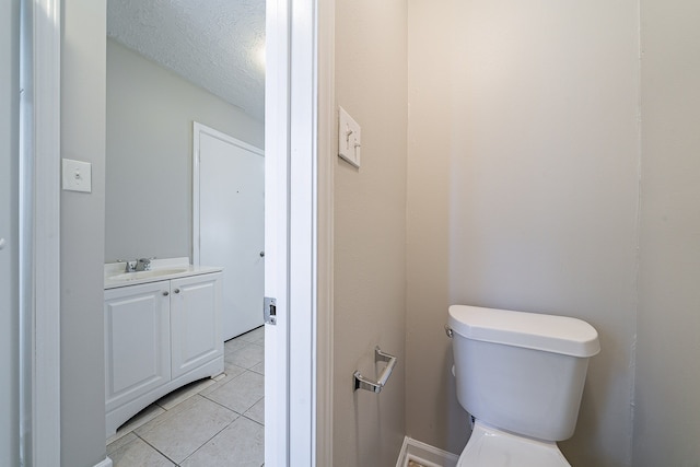 bathroom with tile patterned floors, toilet, vanity, and a textured ceiling