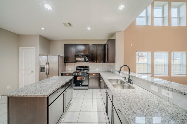 kitchen with visible vents, light tile patterned floors, decorative backsplash, black appliances, and a sink