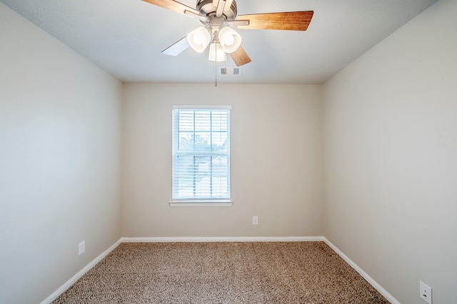 carpeted spare room featuring visible vents, baseboards, and ceiling fan