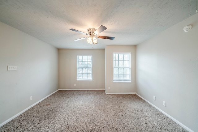 spare room with baseboards, carpet floors, a textured ceiling, and a ceiling fan