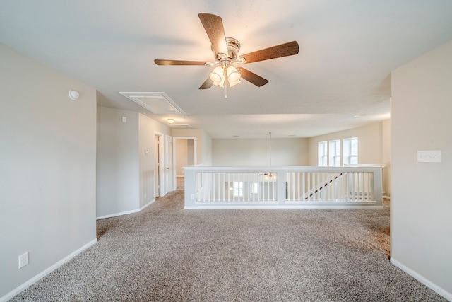 unfurnished room with baseboards, carpet, and attic access