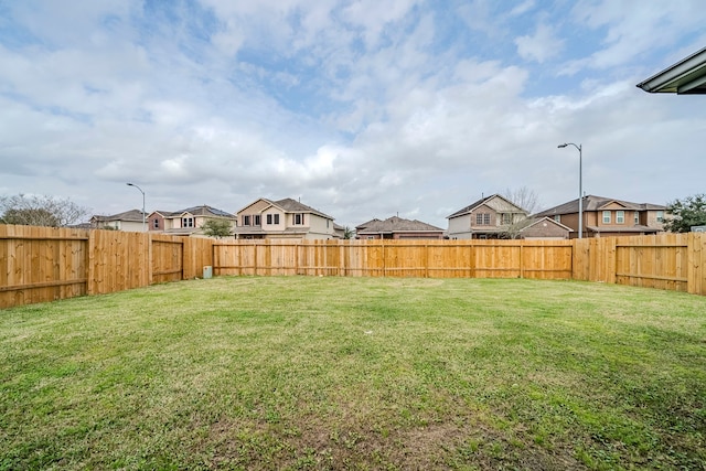 view of yard with a fenced backyard and a residential view