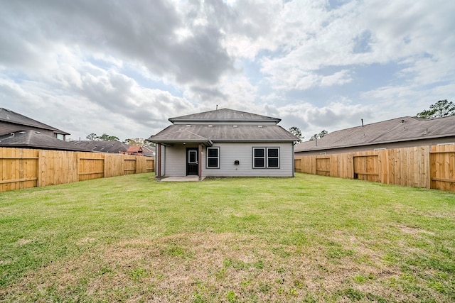 back of property with a patio area, a lawn, and a fenced backyard