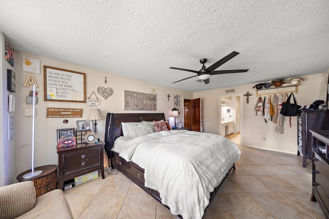 bedroom with a textured ceiling, ensuite bathroom, and ceiling fan