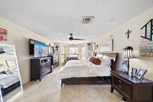 bedroom featuring light tile patterned floors, visible vents, a textured ceiling, and a ceiling fan