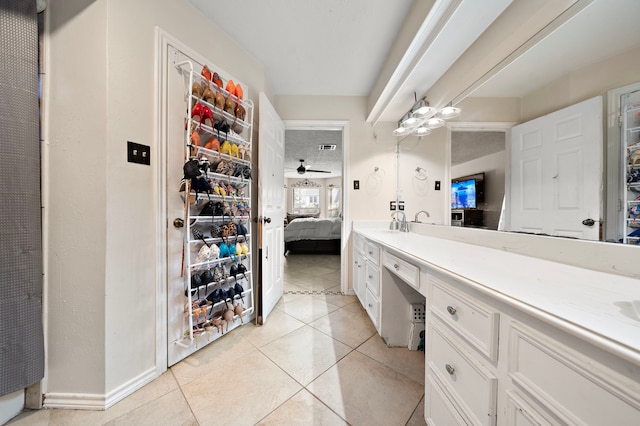 ensuite bathroom featuring vanity, a ceiling fan, baseboards, tile patterned floors, and connected bathroom