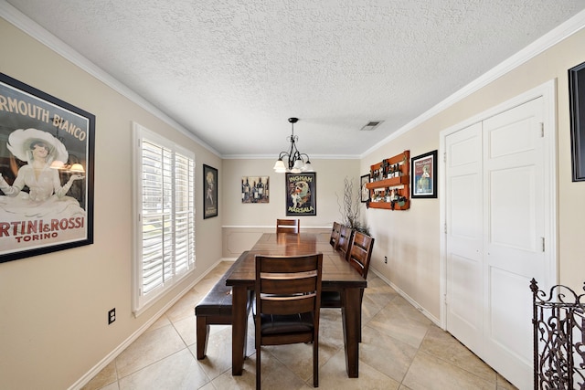 dining area featuring visible vents, ornamental molding, light tile patterned floors, a notable chandelier, and a textured ceiling