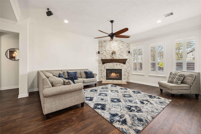 living room with baseboards, visible vents, a fireplace, ornamental molding, and dark wood-type flooring