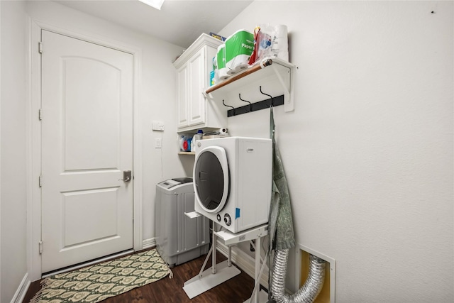 laundry room with baseboards, radiator heating unit, cabinet space, dark wood-type flooring, and washing machine and dryer