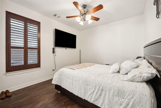 bedroom with visible vents, baseboards, wood finished floors, and a ceiling fan