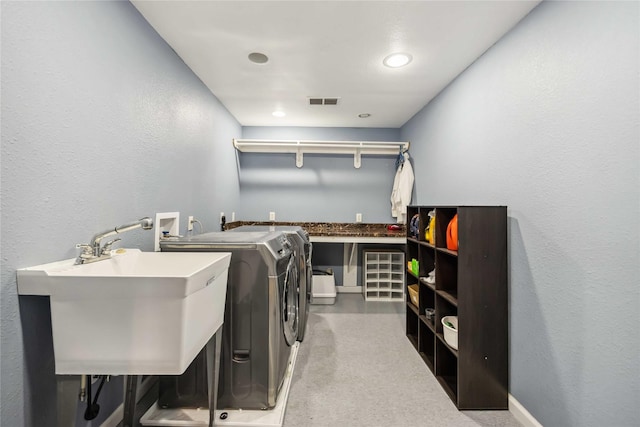 washroom featuring visible vents, independent washer and dryer, a sink, laundry area, and a textured wall