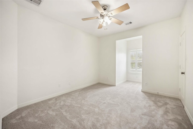 carpeted empty room featuring a ceiling fan, baseboards, and visible vents