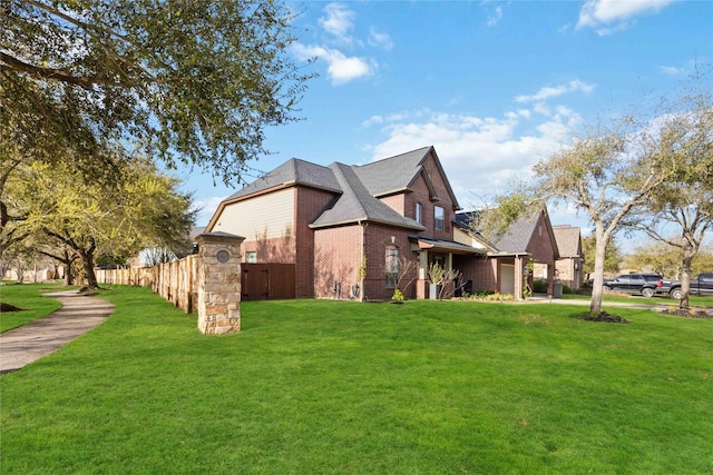 view of property exterior with fence, a yard, an attached garage, a shingled roof, and brick siding