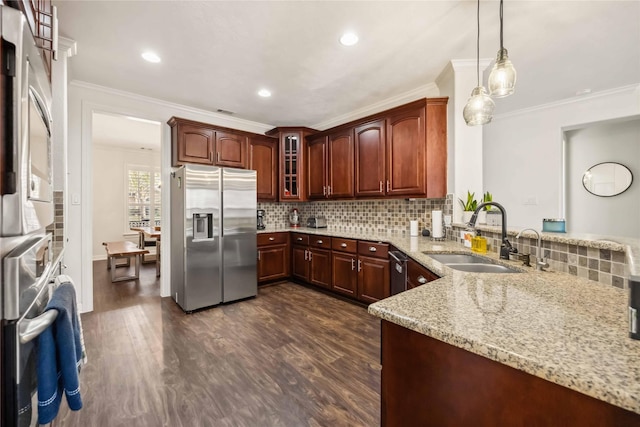 kitchen with tasteful backsplash, light stone countertops, appliances with stainless steel finishes, dark wood-style floors, and a sink