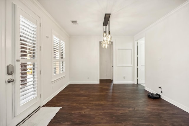 unfurnished dining area featuring a notable chandelier, ornamental molding, baseboards, and wood finished floors