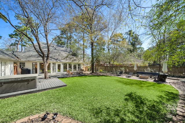 view of yard with a fire pit, a hot tub, french doors, a fenced backyard, and a patio