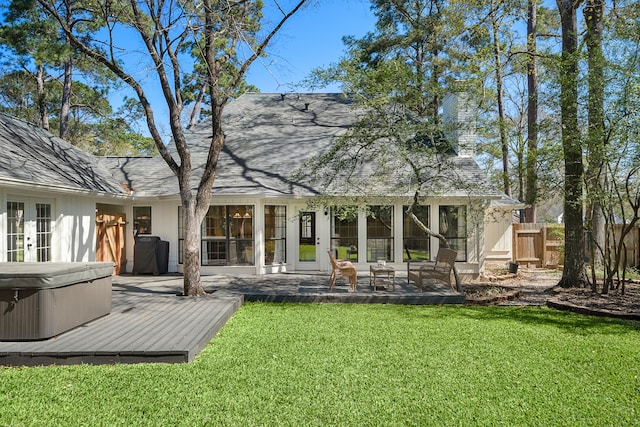 back of house with a hot tub, fence, french doors, a deck, and a yard