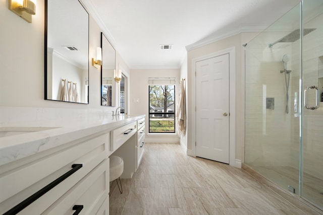 full bath featuring a shower stall, visible vents, and ornamental molding