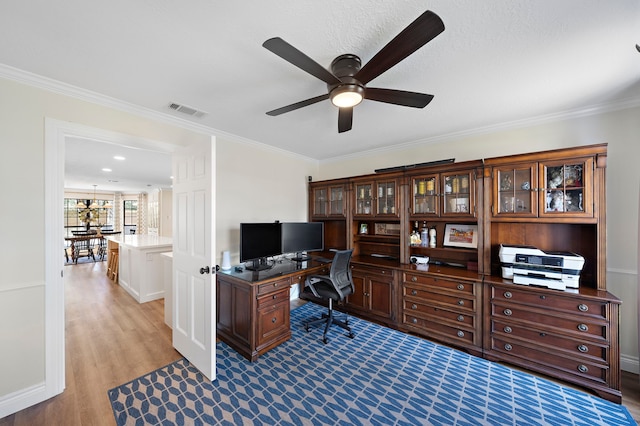 office space with crown molding, wood finished floors, visible vents, and ceiling fan