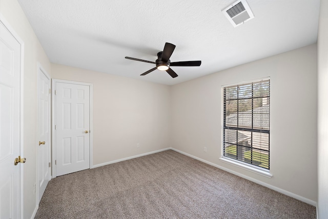 interior space with visible vents, ceiling fan, a textured ceiling, and baseboards