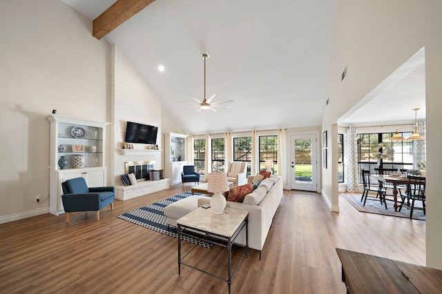 living area featuring wood finished floors, a fireplace, visible vents, and high vaulted ceiling