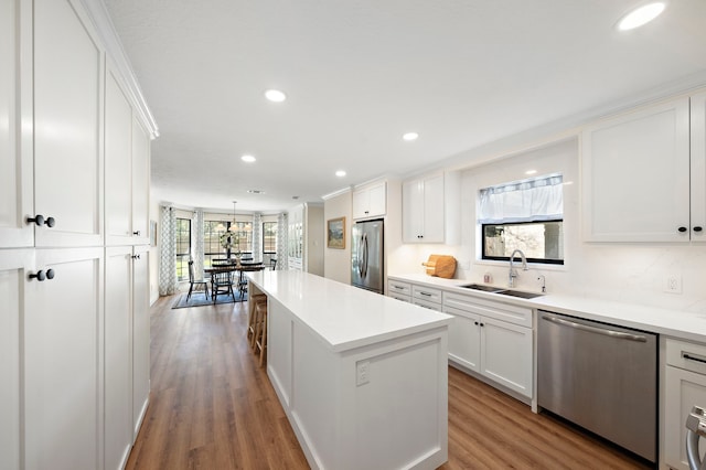 kitchen featuring a sink, a center island, white cabinetry, and stainless steel appliances