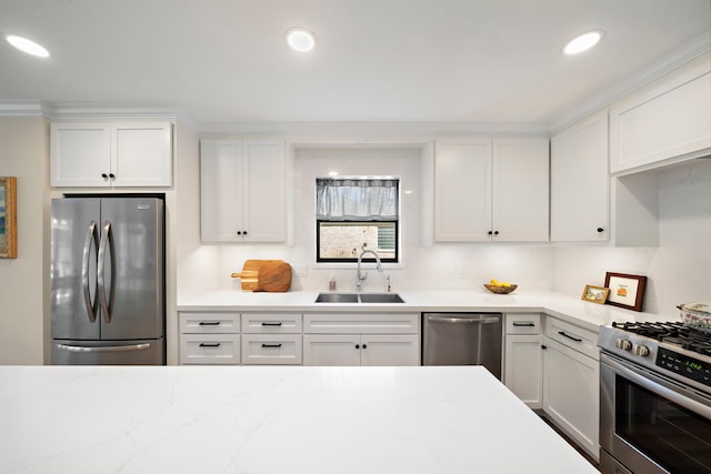 kitchen with light stone counters, recessed lighting, a sink, white cabinets, and appliances with stainless steel finishes