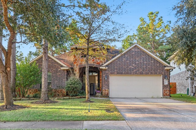 126 Magnolia Grove Ln, Conroe, TX 77384 - view of front of house featuring brick siding, concrete driveway, a front yard, stone siding, and an attached garage