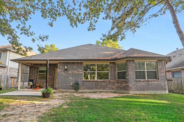 126 Magnolia Grove Ln, Conroe, TX 77384 - back of property featuring brick siding, a patio, a yard, and fence