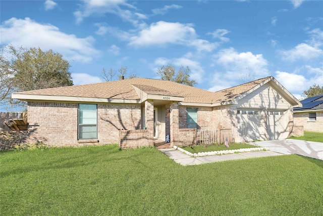 single story home with brick siding, an attached garage, concrete driveway, and a front yard