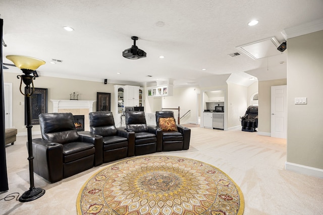 cinema room featuring visible vents, a glass covered fireplace, recessed lighting, baseboards, and light colored carpet