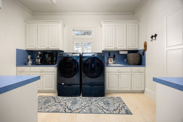 clothes washing area with washer and dryer, cabinet space, and ornamental molding