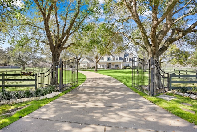 view of community with fence, a yard, and a gate