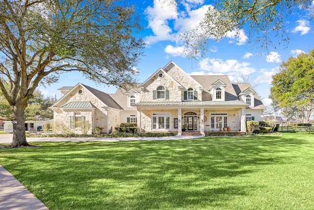 view of front of property with a front lawn, french doors, and stone siding