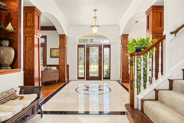 entryway with stairway, decorative columns, baseboards, and ornamental molding