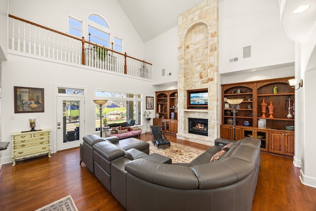 living area featuring visible vents, baseboards, wood finished floors, and a fireplace