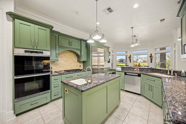 kitchen featuring green cabinetry, visible vents, appliances with stainless steel finishes, and a sink