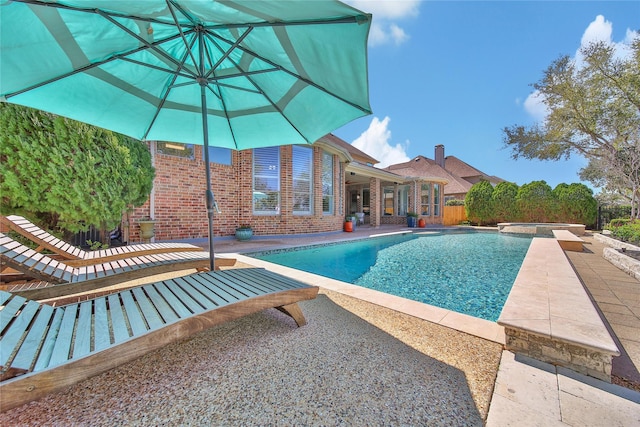 view of swimming pool with a patio and a pool with connected hot tub