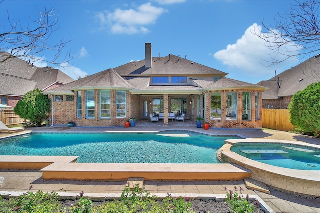 view of pool featuring a patio area, a pool with connected hot tub, and fence