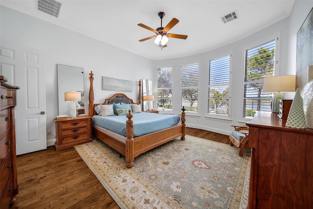 bedroom featuring ceiling fan, visible vents, baseboards, and wood finished floors