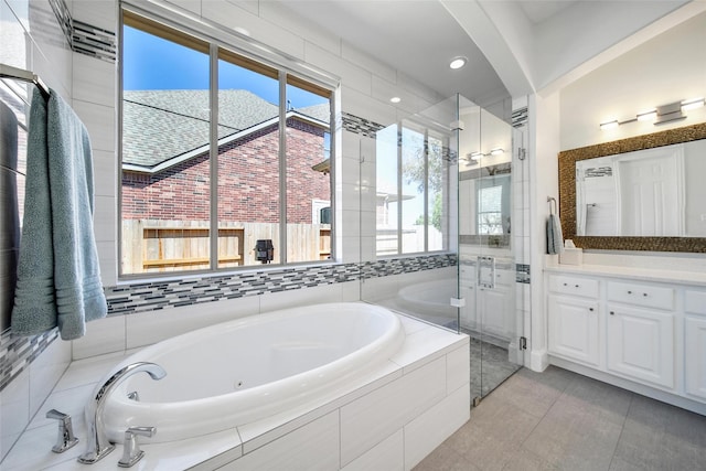 full bathroom featuring tile patterned flooring, a shower stall, vanity, and a garden tub