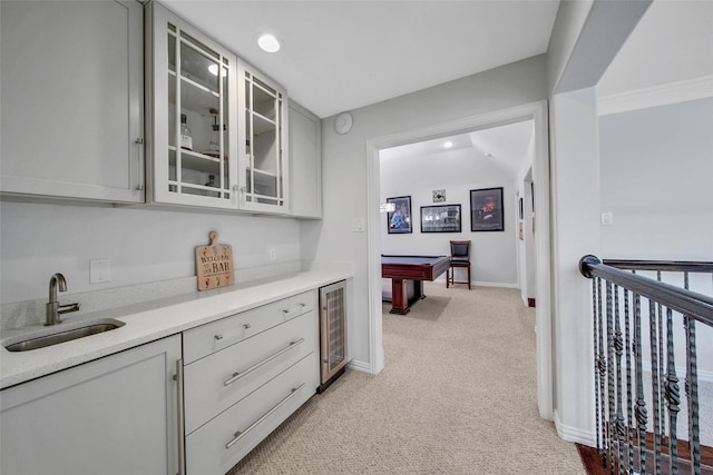 interior space with light carpet, beverage cooler, a sink, recessed lighting, and baseboards