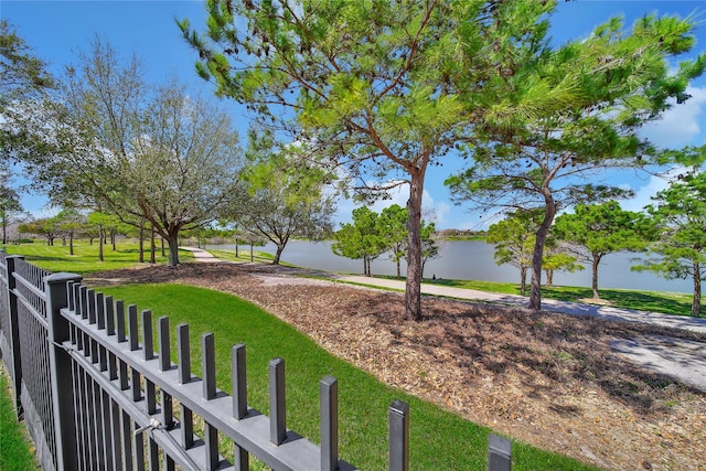 view of yard featuring a water view and fence