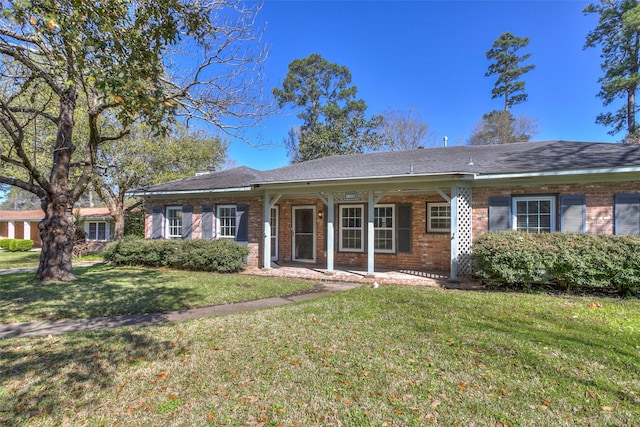 view of front of property featuring brick siding and a front yard