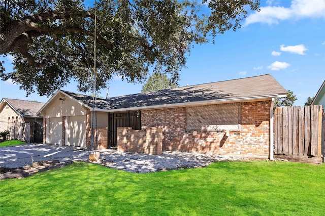 view of front of house with brick siding, a garage, a front lawn, and fence