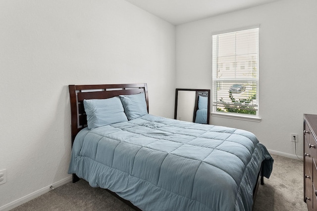 bedroom with baseboards and carpet