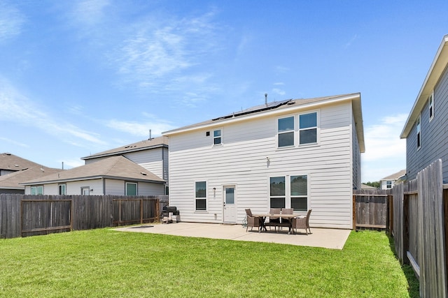 rear view of property with a patio, roof mounted solar panels, a lawn, and a fenced backyard