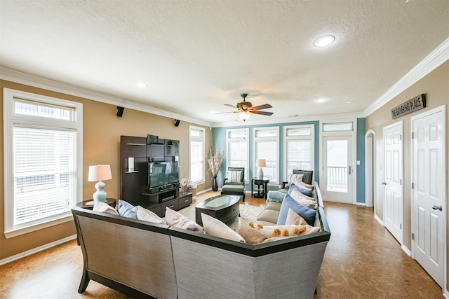 living area featuring crown molding, baseboards, arched walkways, and a textured ceiling