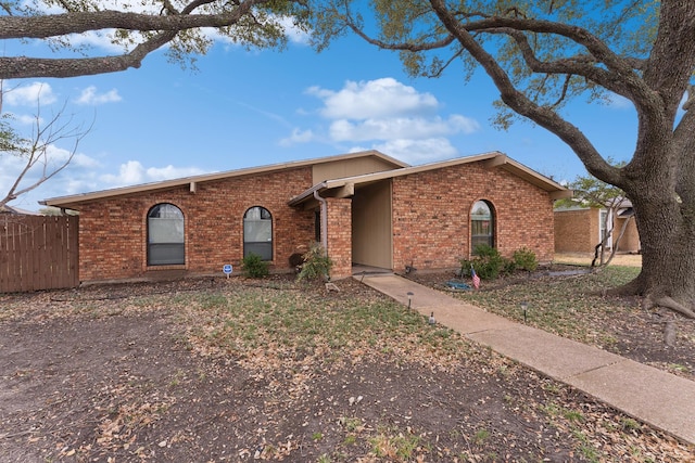 view of front of house with brick siding and fence