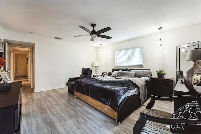 bedroom with visible vents, baseboards, light wood-style floors, and ceiling fan